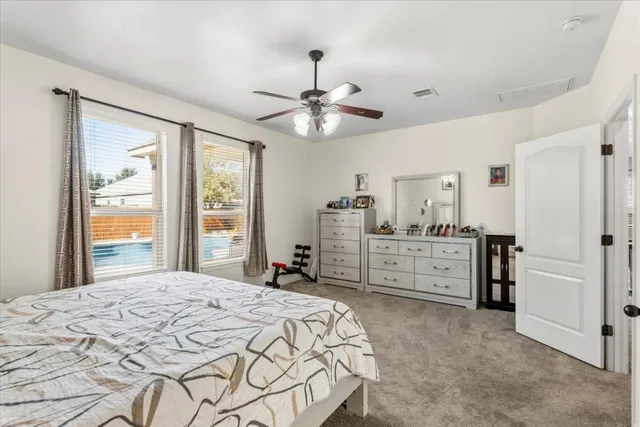a bedroom with a bed dresser and a large window