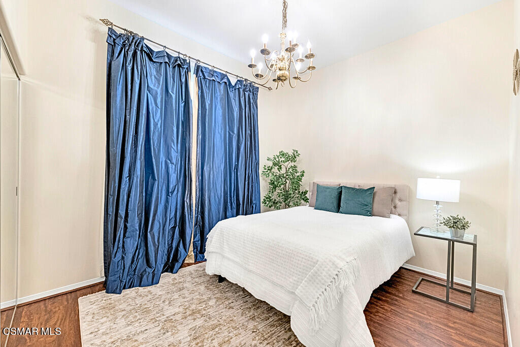 6196 Deerhill Road Oak Park, CA 91377 - Photo 21 of 46 a bedroom with a bed and a chandelier