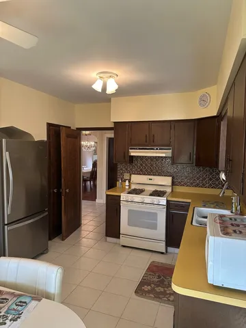 a kitchen with a sink stainless steel appliances a refrigerator and a stove top oven