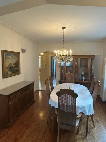 a dining room with furniture a chandelier and wooden floor
