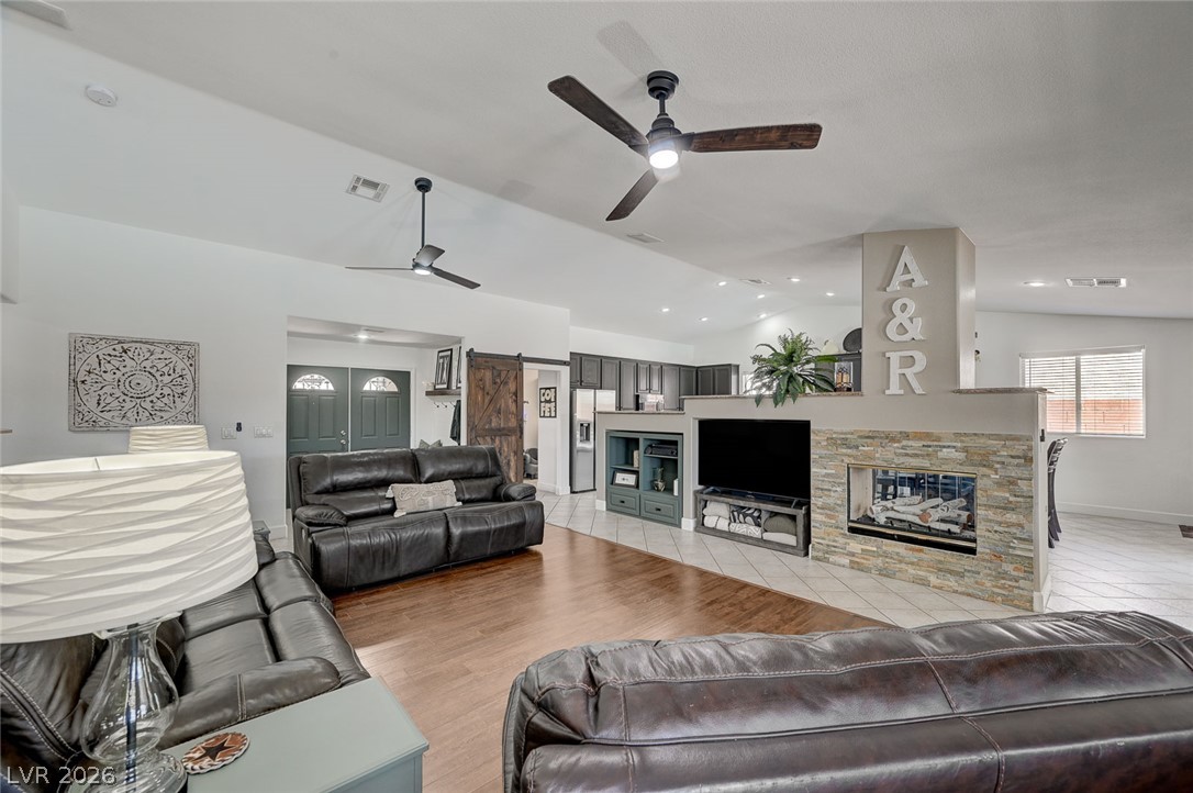 1072 Reed Point Court Henderson, NV 89002 - Photo 12 of 60 An inviting great room with wood flooring, ceiling fans, and a stone-faced fireplace.