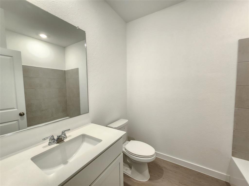 6814 Welsh Drive Princeton, TX 75407 - Photo 11 of 16 a bathroom with a sink a toilet and mirror