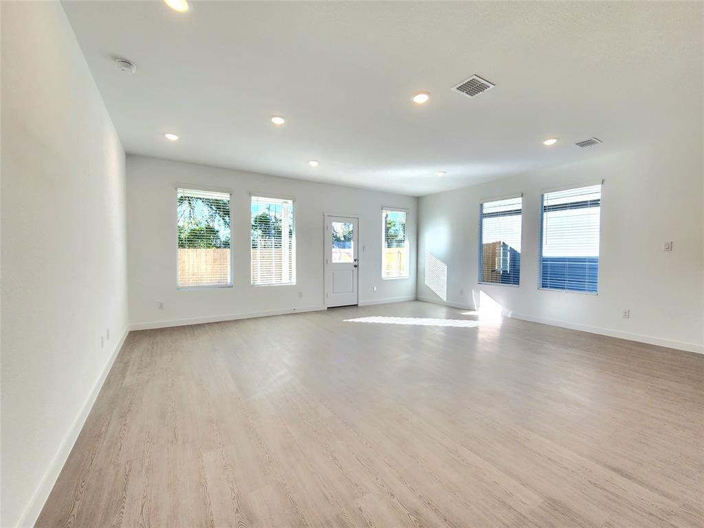 6814 Welsh Drive Princeton, TX 75407 - Photo 2 of 16 an empty room with wooden floor and windows