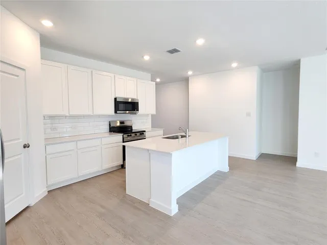 a kitchen with granite countertop white cabinets and white appliances