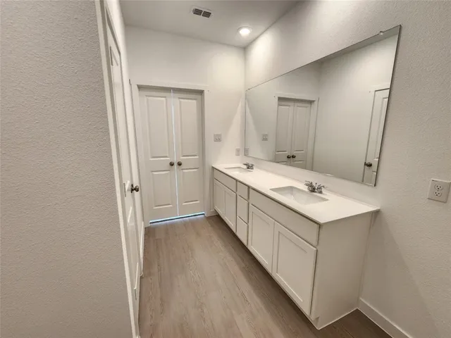 a bathroom with a double vanity sink and mirror