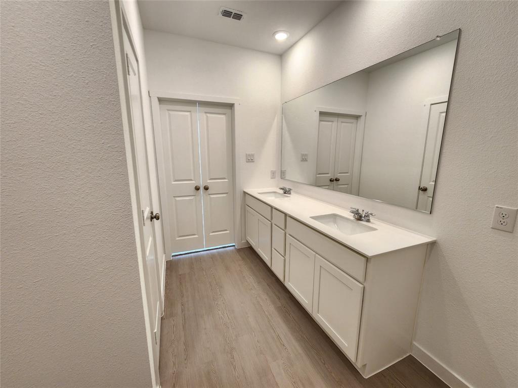 6814 Welsh Drive Princeton, TX 75407 - Photo 10 of 16 a bathroom with a double vanity sink and mirror
