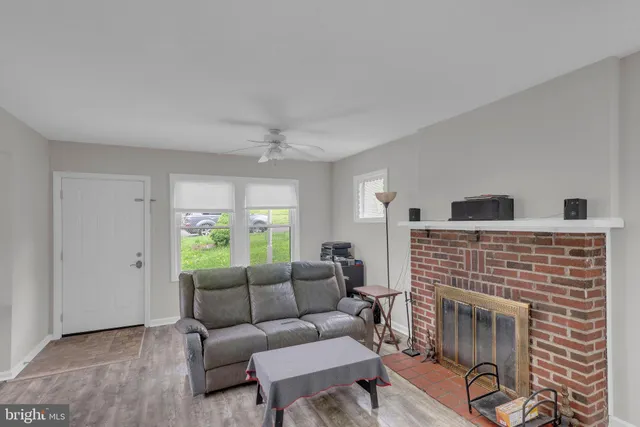 a living room with furniture a large window and a fireplace