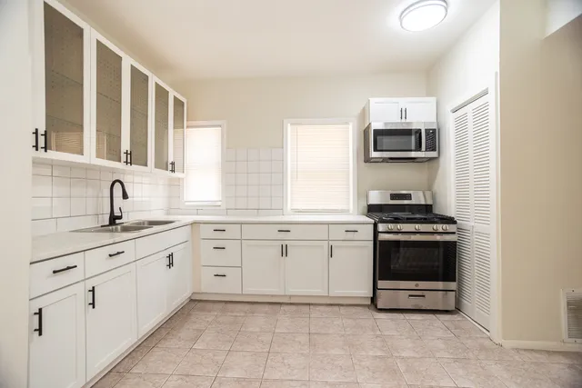 a kitchen with stainless steel appliances granite countertop a sink and a stove