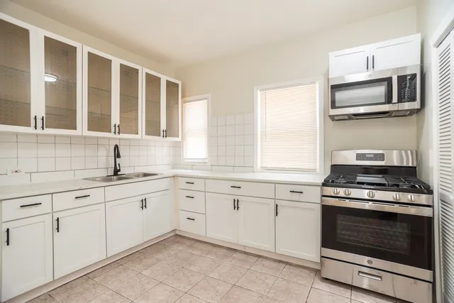 a kitchen with white cabinets stainless steel appliances and sink