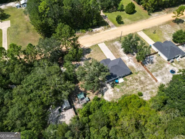 an aerial view of residential houses with outdoor space and trees