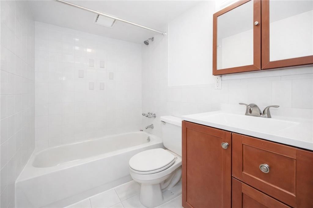 1956 20th Drive Brooklyn, NY 11214 - Photo 15 of 16 a bathroom with a sink a toilet and bathtub