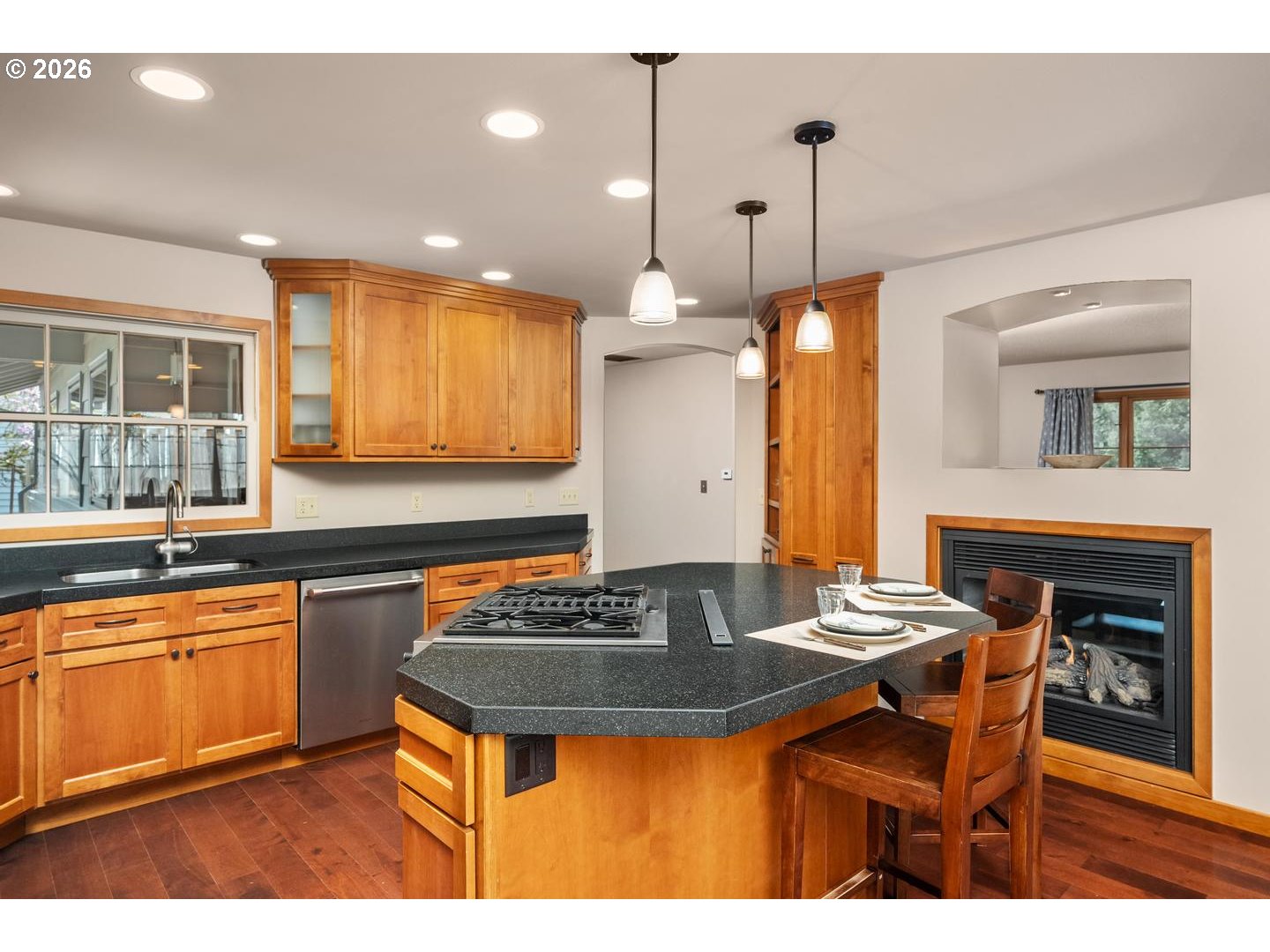 3005 Southwest 113th Avenue Beaverton, OR 97005 - Photo 8 of 30 a kitchen with stainless steel appliances granite countertop a stove a sink dishwasher a dining table and chairs with wooden floor