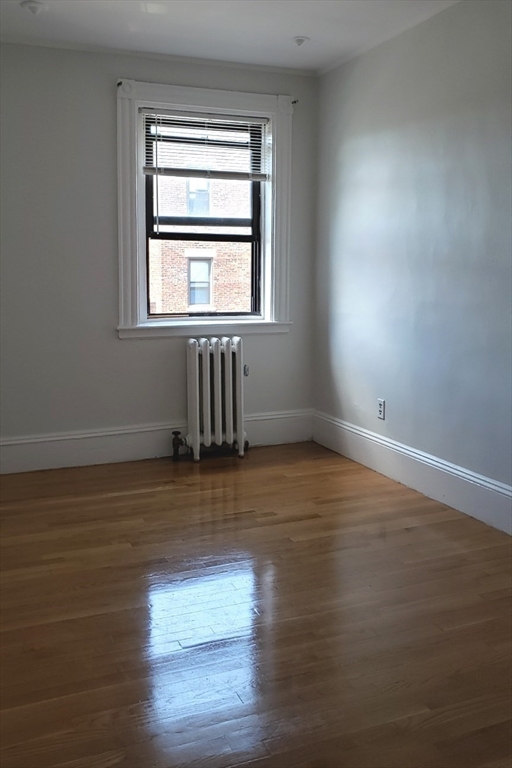 924 Beacon Street, Unit 6 Boston, MA 02215 - Photo 16 of 28 a view of empty room with wooden floor and fan