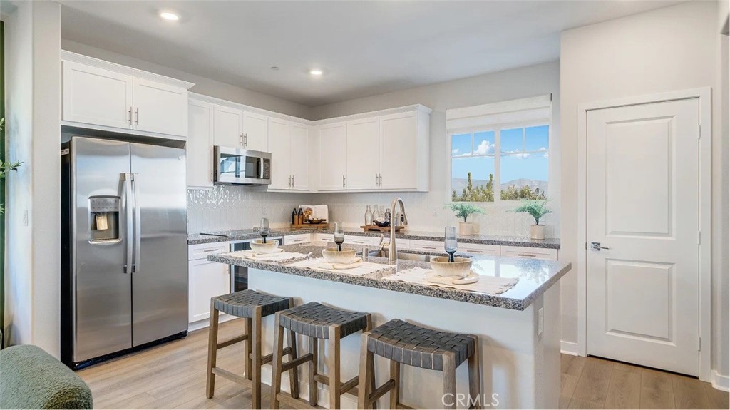 1721 Eagle Road Rialto, CA 92376 - Photo 2 of 23 a kitchen with stainless steel appliances granite countertop a refrigerator a sink a stove a dining table and chairs