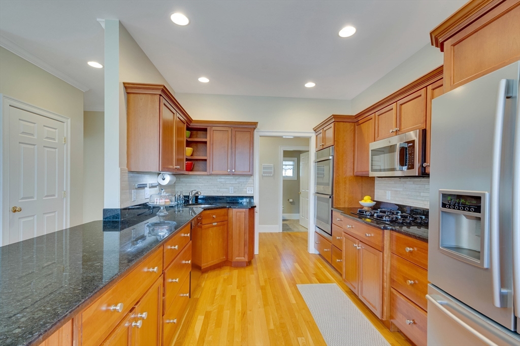 29 Old Bridge Road Concord, MA 01742 - Photo 36 of 40 a kitchen with stainless steel appliances granite countertop a refrigerator a stove and a sink with wooden floor