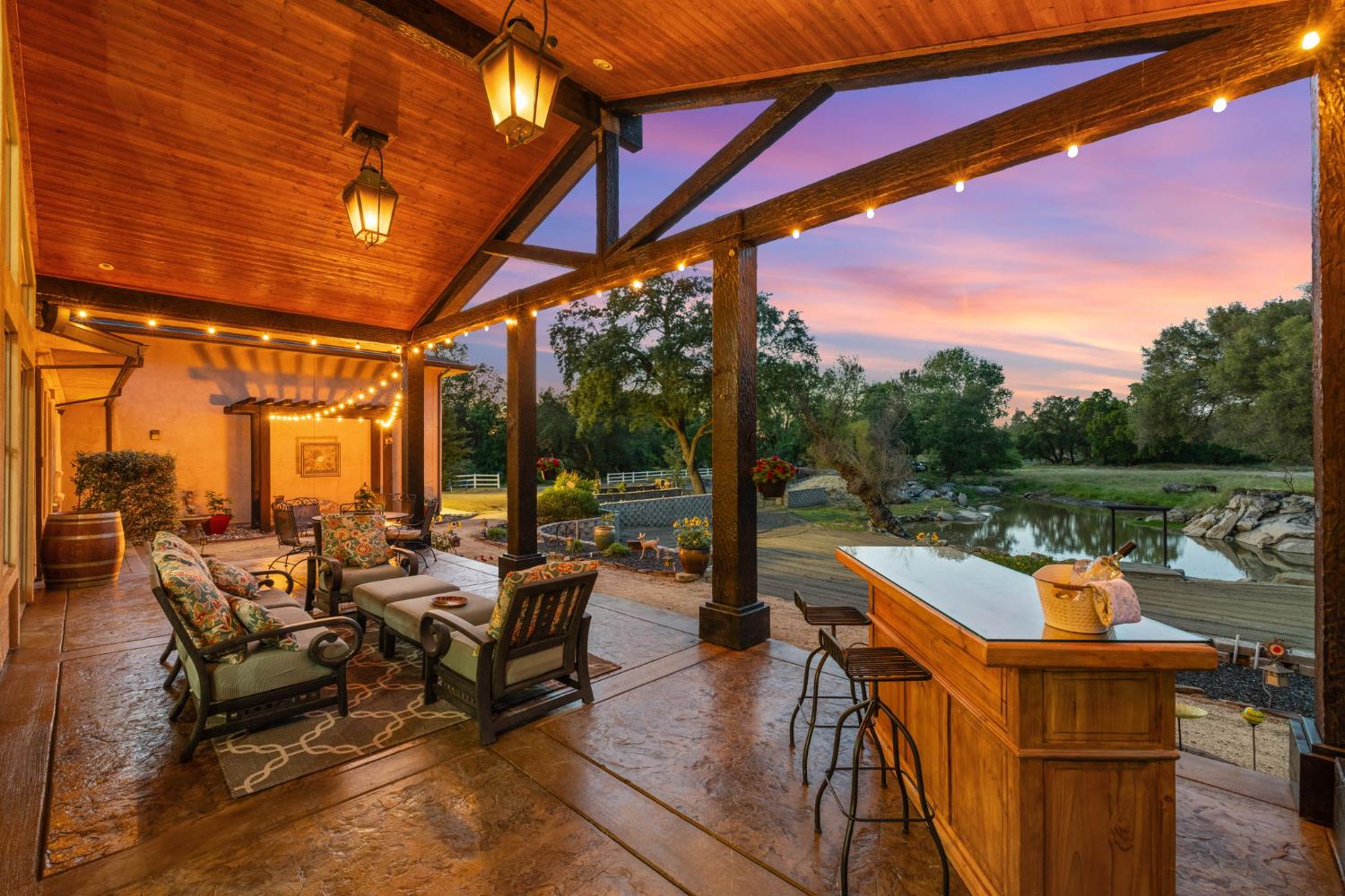 7021 Horseshoe Bar Road Loomis, CA 95650 - Photo 68 of 77 Covered outdoor living with hand-hewn timber beams, stamped stained concrete, propane lanterns, and pond views.