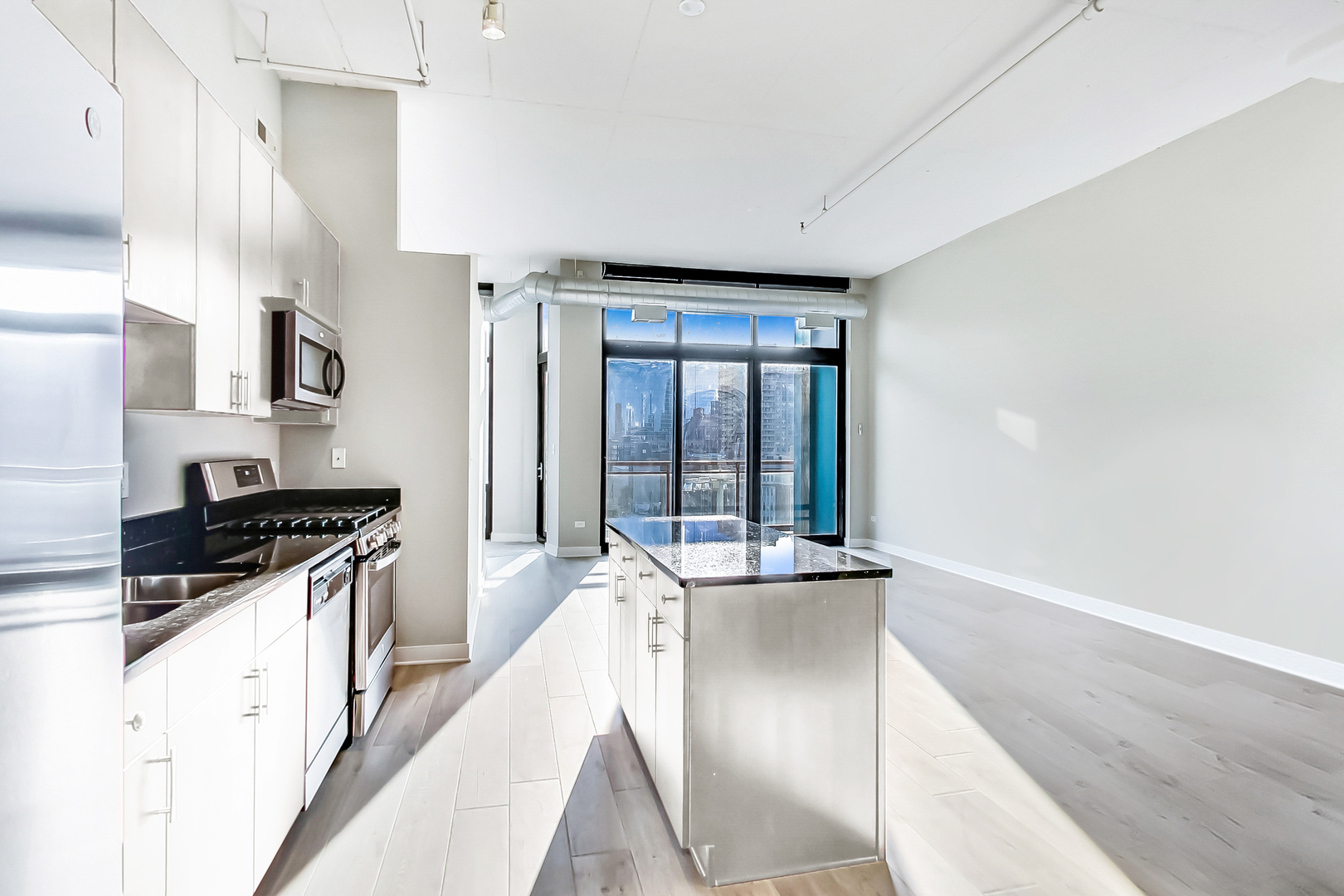 740 West Fulton Street, Unit 905 Chicago, IL 60661 - Photo 11 of 23 a kitchen with granite countertop a sink a counter top space stainless steel appliances a counter space and cabinets