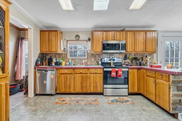 a kitchen with stainless steel appliances granite countertop a stove a sink and a refrigerator