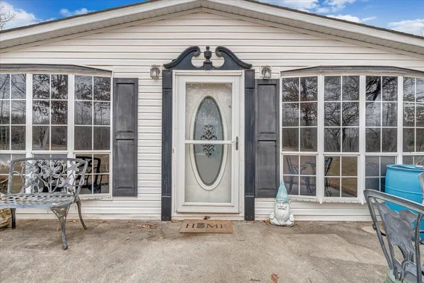 a view of a grey house with large windows