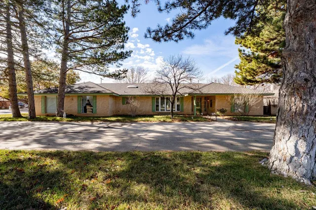 a view of a dining room with furniture a chandelier and a window