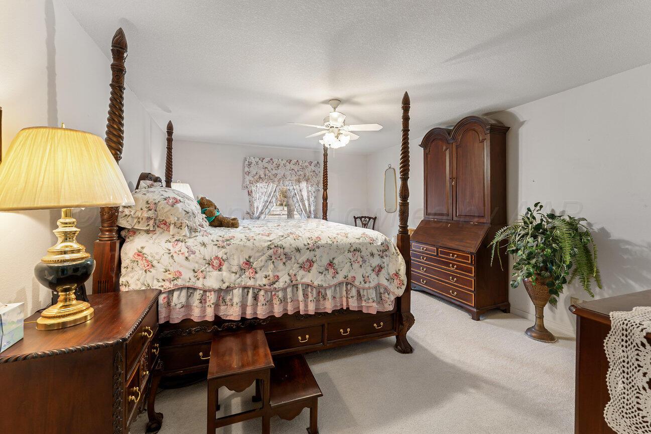 201 Carson Avenue Dumas, TX 79029 - Photo 21 of 55 a bed room with a bed and a potted plant