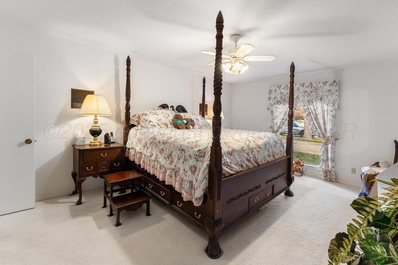 201 Carson Avenue Dumas, TX 79029 - Photo 22 of 55 a bedroom with a bed and a chandelier