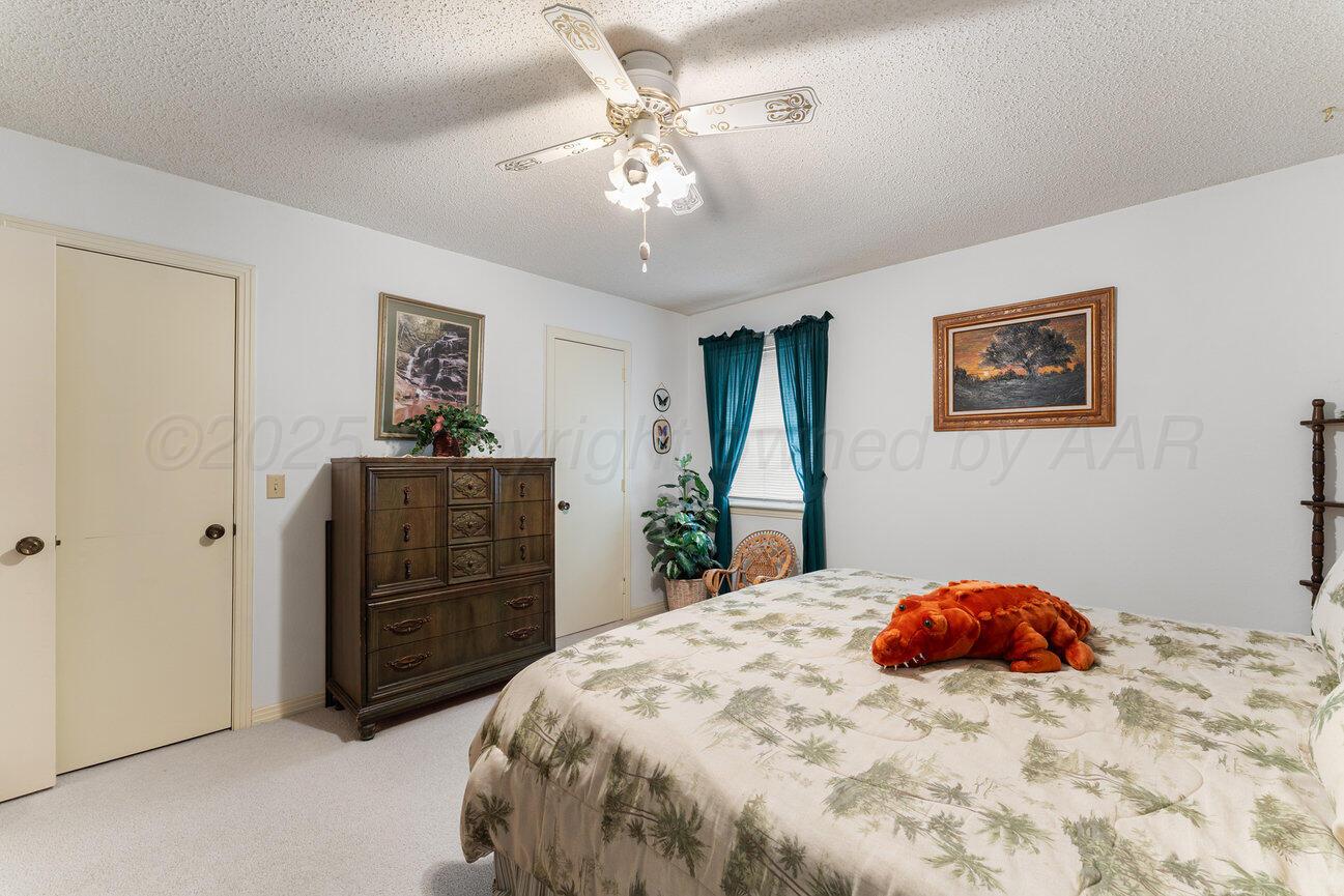 201 Carson Avenue Dumas, TX 79029 - Photo 28 of 55 a bedroom with a bed and a chandelier