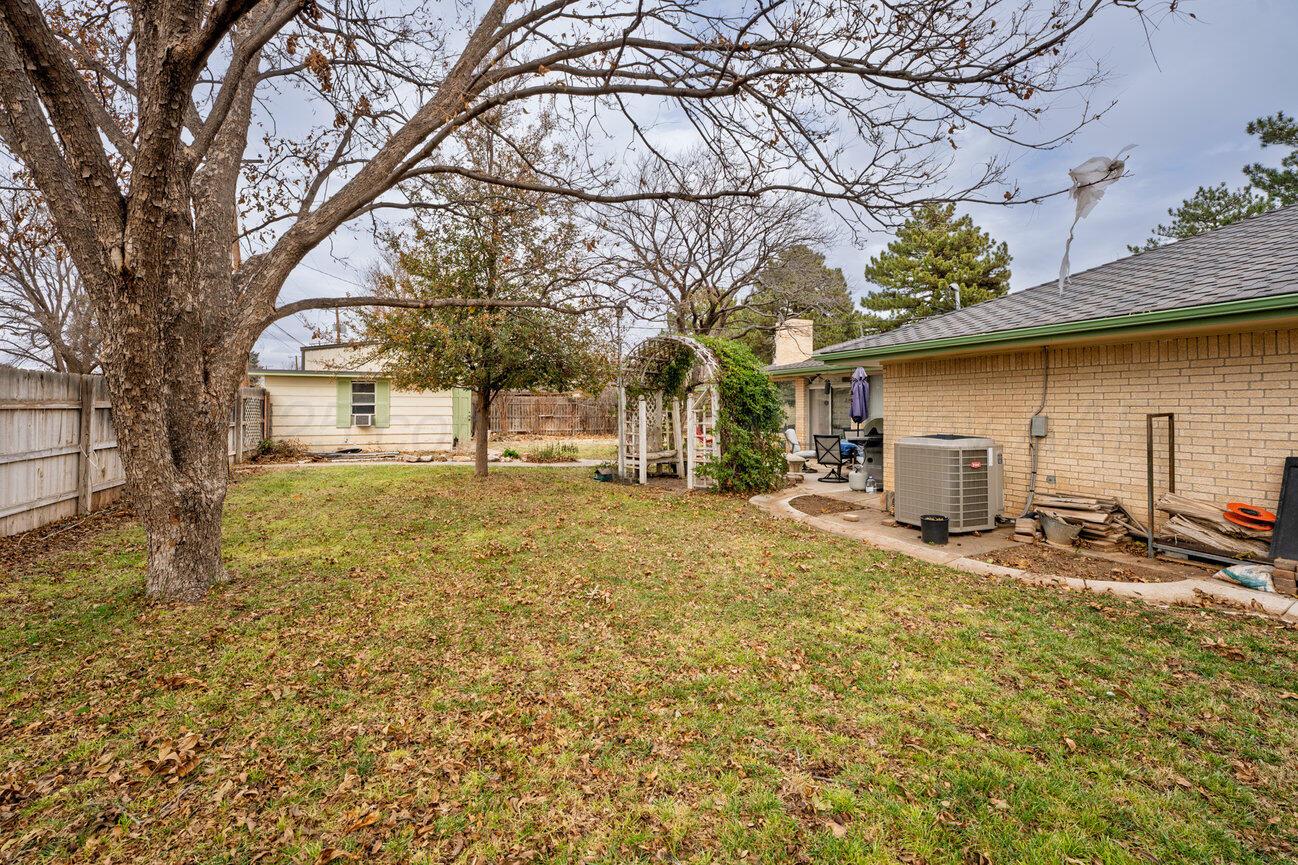 201 Carson Avenue Dumas, TX 79029 - Photo 55 of 55 a backyard of a house with table and chairs under an large tree