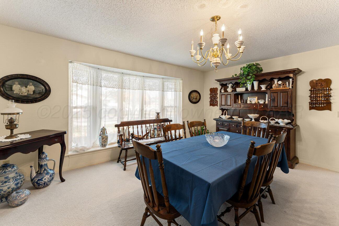 201 Carson Avenue Dumas, TX 79029 - Photo 6 of 55 a view of a dining room with furniture a chandelier and a window