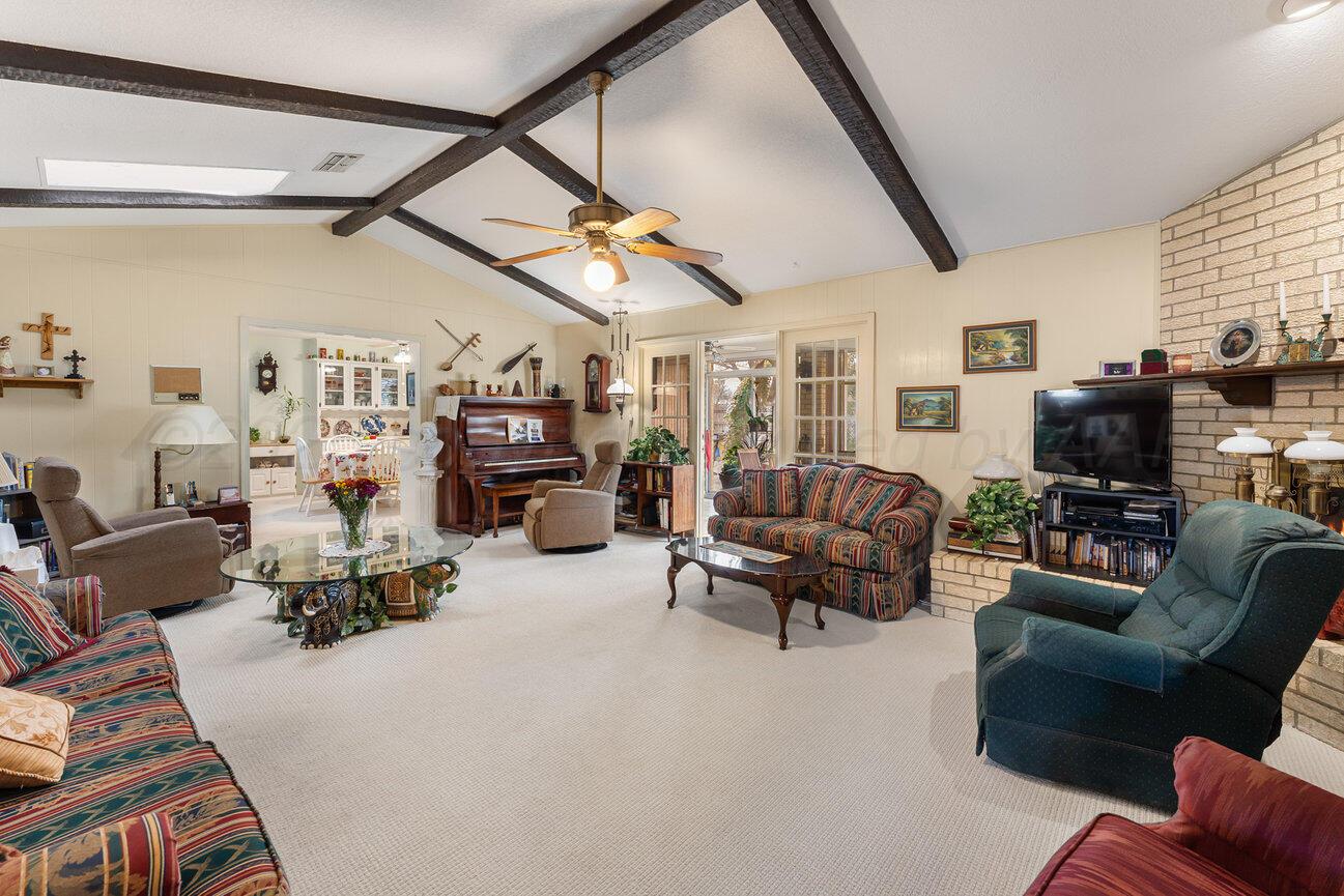 201 Carson Avenue Dumas, TX 79029 - Photo 8 of 55 a living room with furniture a fireplace and a flat screen tv