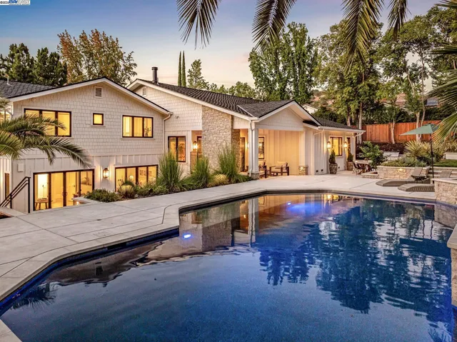 a view of a house with pool and sitting area