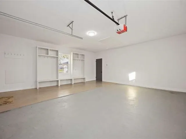 an empty room with ceiling fan and windows
