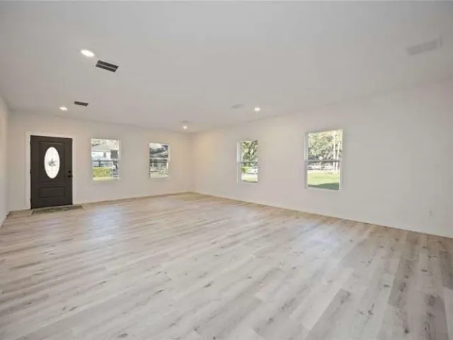 an empty room with windows and cabinet