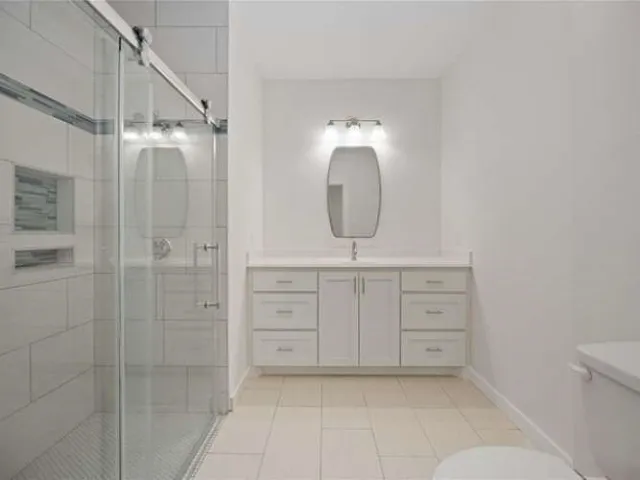 a bathroom with a sink a toilet and shower