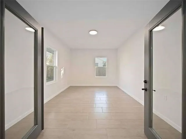 an empty room with windows and closet