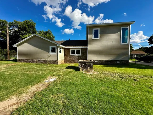 a front view of house with yard and trees in the background