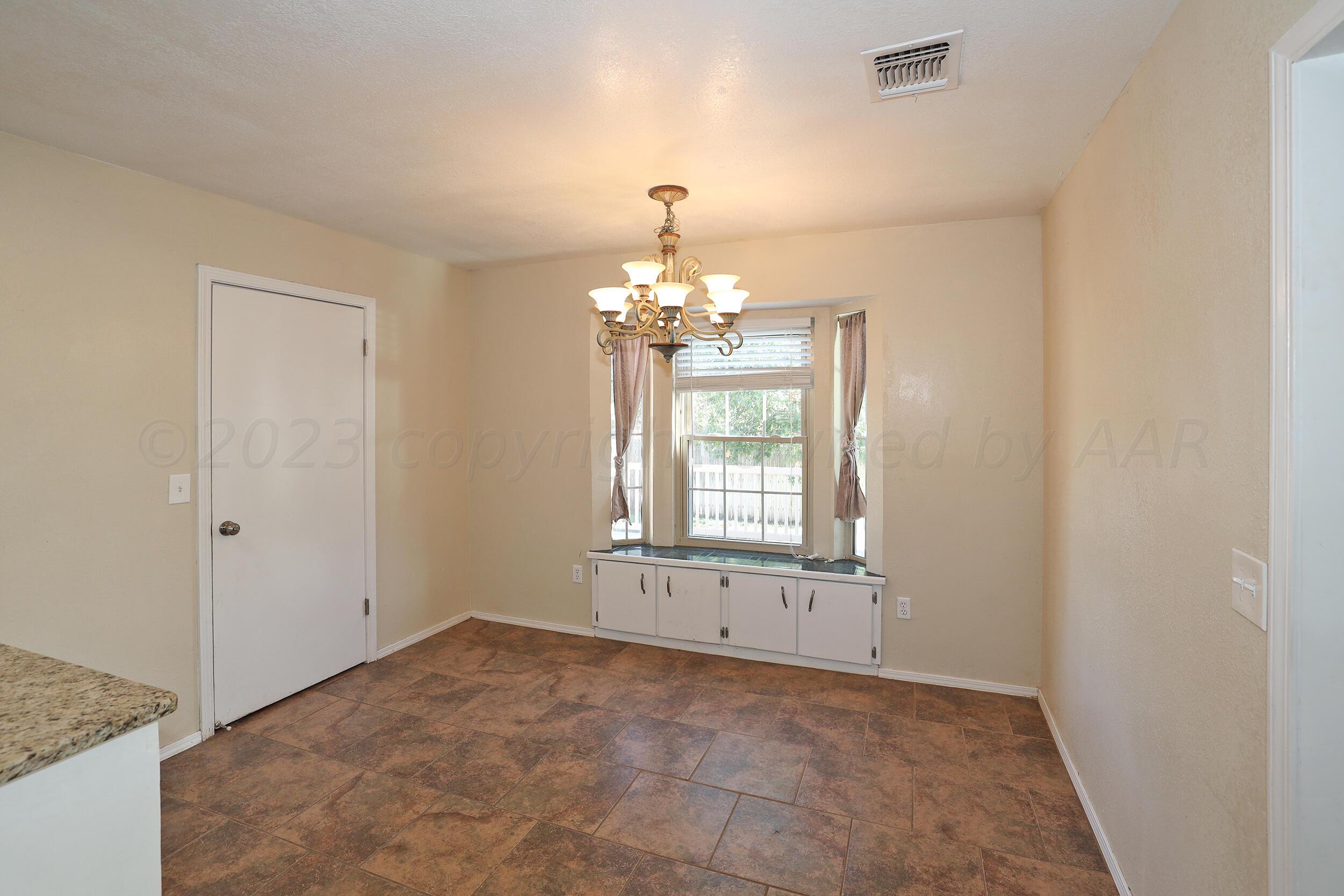 2905 Salem Drive Amarillo, TX 79110 - Photo 8 of 29 an empty room with chandelier and windows