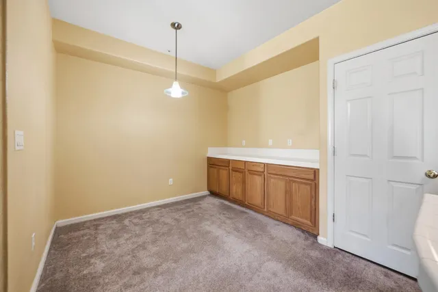 a view of an empty room with window and cabinet