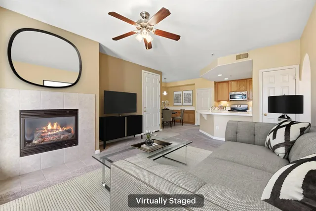 a living room with furniture a flat screen tv and a fireplace