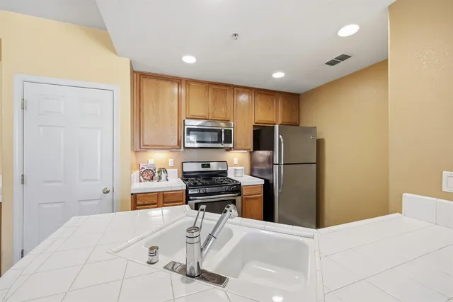 a kitchen with a refrigerator a stove and a sink