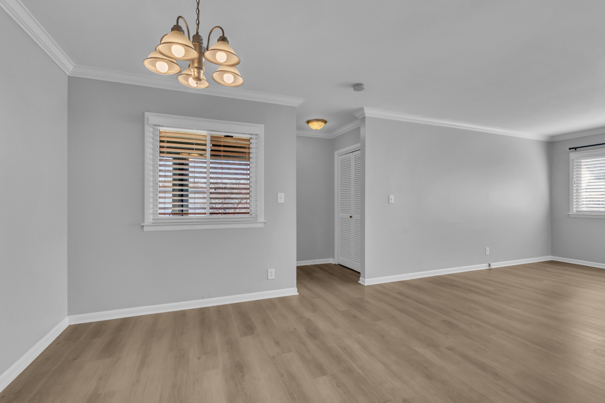 1900 Richard Jones Road, Unit R8 Nashville, TN 37215 - Photo 1 of 21 an empty room with wooden floor chandelier fan and windows