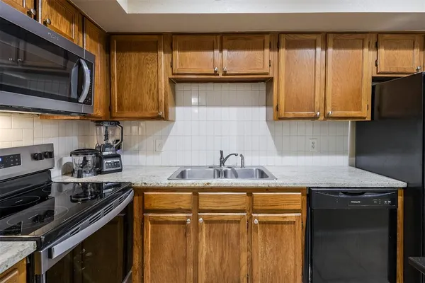 a kitchen with stainless steel appliances granite countertop a sink stove and microwave