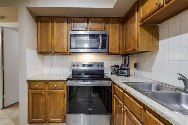a kitchen with granite countertop a sink and a stove top oven