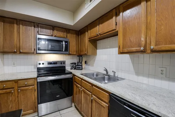 a kitchen with granite countertop wooden cabinets and black appliances