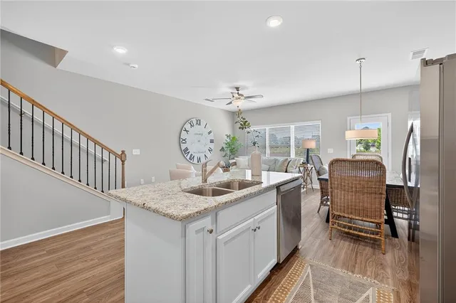 a kitchen with stainless steel appliances granite countertop sink cabinets and wooden floor
