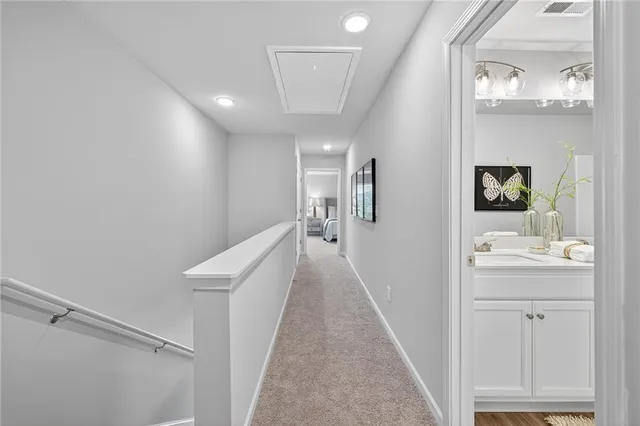 a view of a hallway with bathroom and wooden floor