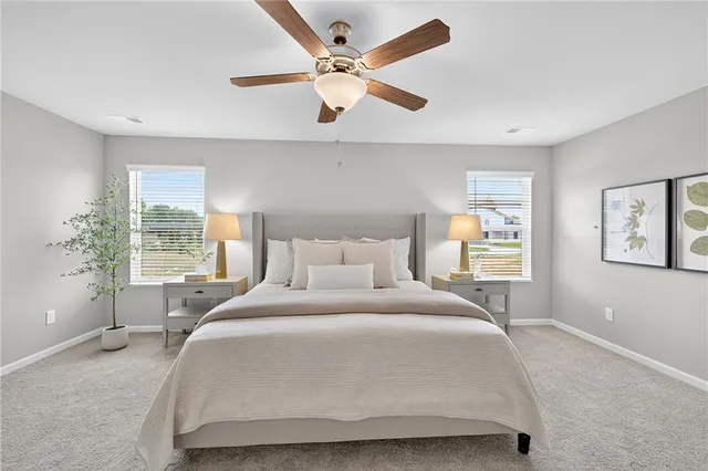 a bedroom with a large bed large window with table and chair