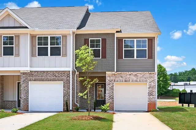 a front view of a house with a garden and yard