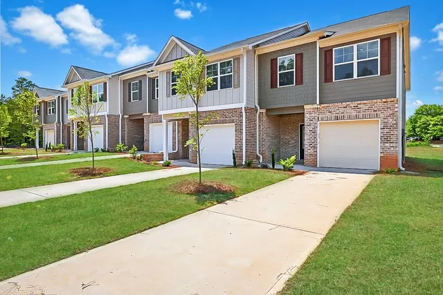 a front view of a house with a yard and trees