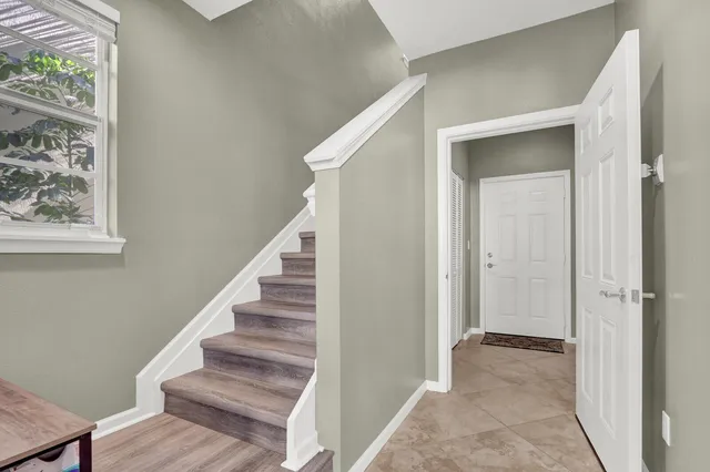 a view of a hallway with wooden floor and entryway